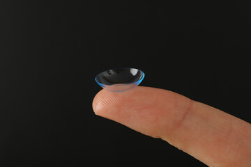 Close-up of a clear contact lens on a fingertip