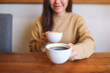 © Farknot Architect - Closeup image of a young woman holding and serving two cups of hot coffee