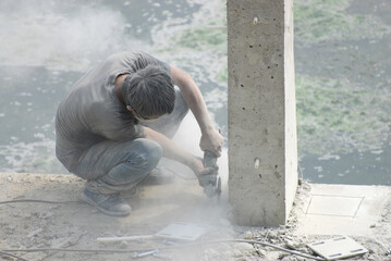 Wall Mural - worker cutting concrete with dust at construction site