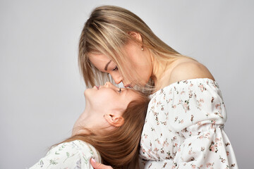 Wall Mural - Portrait of young mother and daughter. Happy woman with child girl. Family portrait on a white background