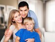 © BillionPhotos.com - Loving family sitting on couch in room
