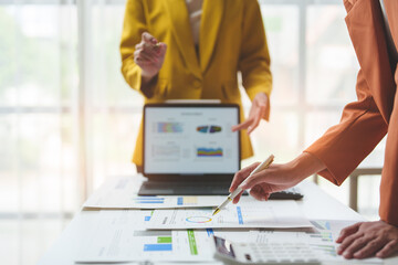 Wall Mural - Financial teamwork with marketing and accounting, professional businesswomen working together at desks, pointing out financial data in report negotiations, analysis, discussion, discussion in office.