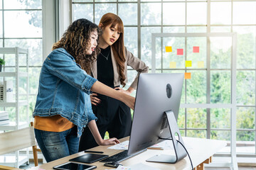 Collaboration of graphic design business people with computer in an office company, Two corporate women in creative marketing team working on project management