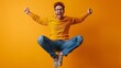 © amixstudio - A joyful young man in a bright yellow sweater and blue jeans jumps in the air with excitement against a vibrant orange background.