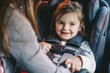 © alisaaa - Close Up Shot of a Beautiful Cheerful Little Girl Happy to Go for a Car Ride Portrait of a cute girl excited while sitting in a car safety seat. Her anonymous mother helping her little daughter to buc