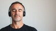 © ChaoticMind - A man wearing black headphones along with a black T-shirt is portrayed in this image, representing modern listening technology and simple contemporary fashion.