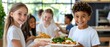 © TEERAWAT - Happy children enjoying healthy meals together in a bright cafeteria setting, promoting friendship and good nutrition. Laughing and chatting concept.