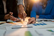 © Wasana - Two people are looking at a table with graphs and charts