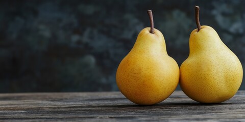 Two pears are sitting on a wooden table. The pears are ripe and ready to eat