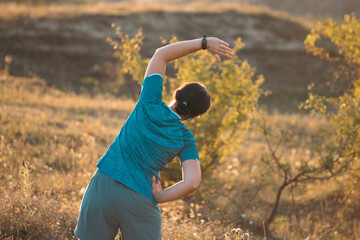 Woman in sportswear stretching for cardio workout or training in nature.