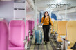 © Wicitr - Businesswoman Walking Through Empty Airplane Cabin: A stylish businesswoman confidently walks through an empty airplane cabin, rolling her suitcase, with an air of excitement for her upcoming journey.