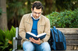 © Vanessa - Male student reading a book on a bench outdoor