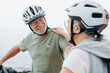 © Daniel - Senior couple riding bikes together in rocky beach enjoying outdoor. Active mature people talking and hugging each others. Bicycle lifestyle concept, having fun