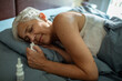 © Marko Geber - Elderly woman sleeping in bed with tissue in hand nose spray next to her