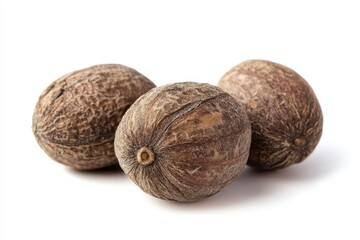 Wall Mural - Three brown, textured seeds arranged on a white background.