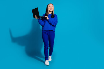 Canvas Print - Portrait of japanese young girl with dyed brunette hair wear trendy outfit using laptop searching new job isolated on blue color background