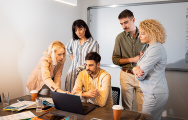 Group of business people sitting in a meeting room discussing a design for a smartphone application.