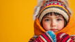 © Vivid_Vision - an Indigenous child in a warm hoodie and mittens on an isolated light yellow background with copy space