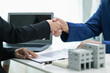 © thatinchan - real estate agent shakes hands with customer after agreeing to sign sales contract and signing contract deliver real estate customer. concept of success in agreeing to sign real estate sales contract