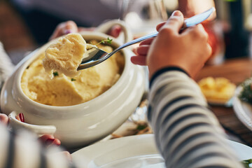 Hand, person and serve mash potato for thanksgiving feast, celebration or holiday pov. Food, spoon and dinner at table with family for lunch, brunch or eating closeup at social event in home together