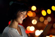 © StarDweller/peopleimages.com - Tablet, night and happy business woman in city for info, research story and news on deadline. Tech, scroll and check email, update and reading notification for project approval with editor on bokeh