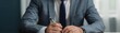 © Samon - Businessman in a suit signs a document at a desk. Professional setting, focus on hands and pen. Career, corporate, executive environment.
