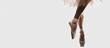 © Ilgun - Close up of ballerina legs in pointe shoes against a white background A classic and modern ballet theme with copy space Cropped panorama showcasing a dancer s legs crossed in a ballet position