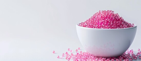 Wall Mural - Pink sugar dragee in a white bowl on a white background copyspace