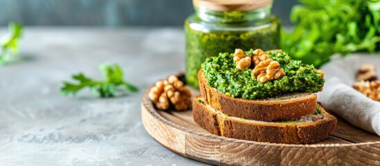 Wall Mural - Arugula pesto with walnuts Pesto sandwich on a wooden plate alongside a jar of pesto Healthy breakfast Vegetarian dish Selective focus copy space close up rustic Keto diet Vertical image