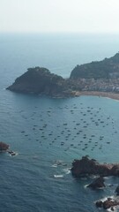 Wall Mural - aerial panoramic view of the city, fortress and beach, bay with boats and yachts. Tossa de Mar  in Catalonia, Spain coastal Costa Brava. summer heat air. Top view from above vertical video footage