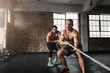 © peopleimages.com - Men, friends and pulling rope for fitness at gym for bodybuilding with strength and determination. Partners, muscles and strong on training, workout and exercise for health, wellness and challenge