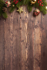 Wall Mural - Top vertical view of Christmas decorations on a rustic wooden background, featuring festive ornaments, greenery, and a cozy holiday atmosphere