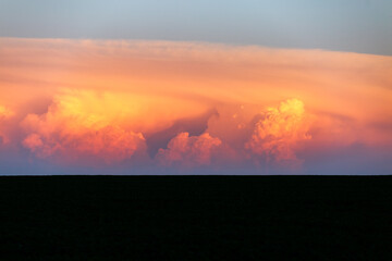 Wall Mural - an incredible colorful sunset with cumulonimbus clouds illuminated by the sun.