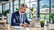 © Man888 - A professional businessman sits at his desk, surrounded by papers and office supplies, working diligently on a laptop in a modern corporate environment.