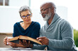 © SensSai/peopleimages.com - Support, park or senior couple reading book or bible in spiritual religion for peace, guidance or learning. Story, interracial marriage and people in nature for scripture, worship or prayer for faith