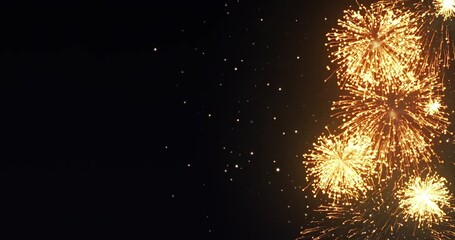 Wall Mural - looping animation of golden fireworks display on a black background with copy space