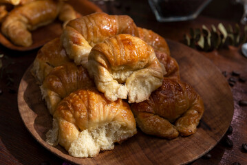 Butter croissants on a wooden plate with ingredients for breakfast or a snack and coffee beans 