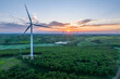 © zhu difeng - view of wind power turbine in field at sunset