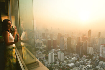 Pretty caucasian woman tourist stand isolated on stunning Thailand capital city Bangkok viewpoint on colorful sunset enjoy illuminated city skyline panorama. Hidden gem scenic view.