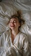 © liliyabatyrova - A woman is smiling and laughing while laying in bed
