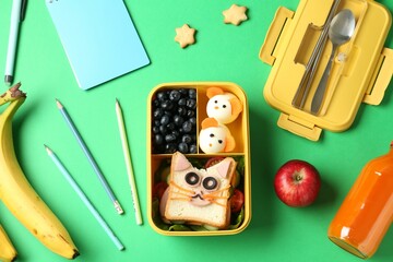 Poster - Lunch box with snacks, bottle of juice, cutlery and stationery on green table, flat lay