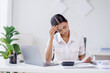 © David - Portrait of tired young business Asian woman work with documents tax laptop computer in office. Sad, unhappy, Worried, Depression, or employee life stress concept.
