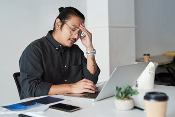 Poster - Asian man, headache and laptop glitch in office, stress and 404 error or burnout for bankruptcy. Male person, glasses and frustrated for proposal or project, depression and anxiety for business