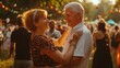 © A Denny Syahputra - An older couple dances happily together at a lively outdoor festival filled with joyful attendees and colorful decorations