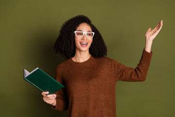 Poster - Portrait of pretty young woman read book speak wear sweater isolated on khaki color background