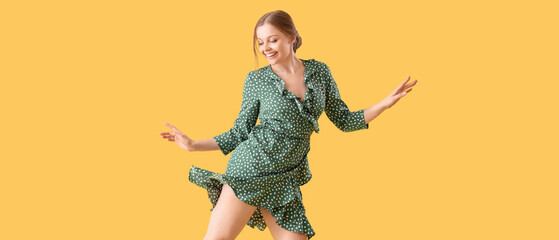 Canvas Print - Beautiful young happy woman dancing on yellow background