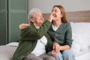 Poster - Senior woman touching her granddaughter's nose in bedroom