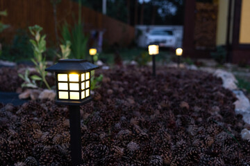 Solar-powered lanterns for flower beds in the yard of the house for decorative street lighting and landscaping