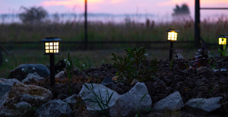 Solar-powered lanterns for flower beds in the yard of the house for decorative street lighting and landscaping