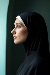 Canvas Print - Side profile of a nun looking out of a small arched window in deep thought soft light highlighting her peaceful expression 